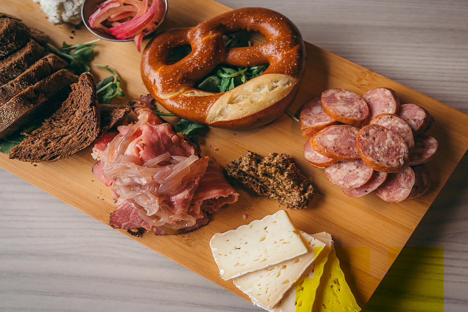 Charcuterie board with pretzels and meat