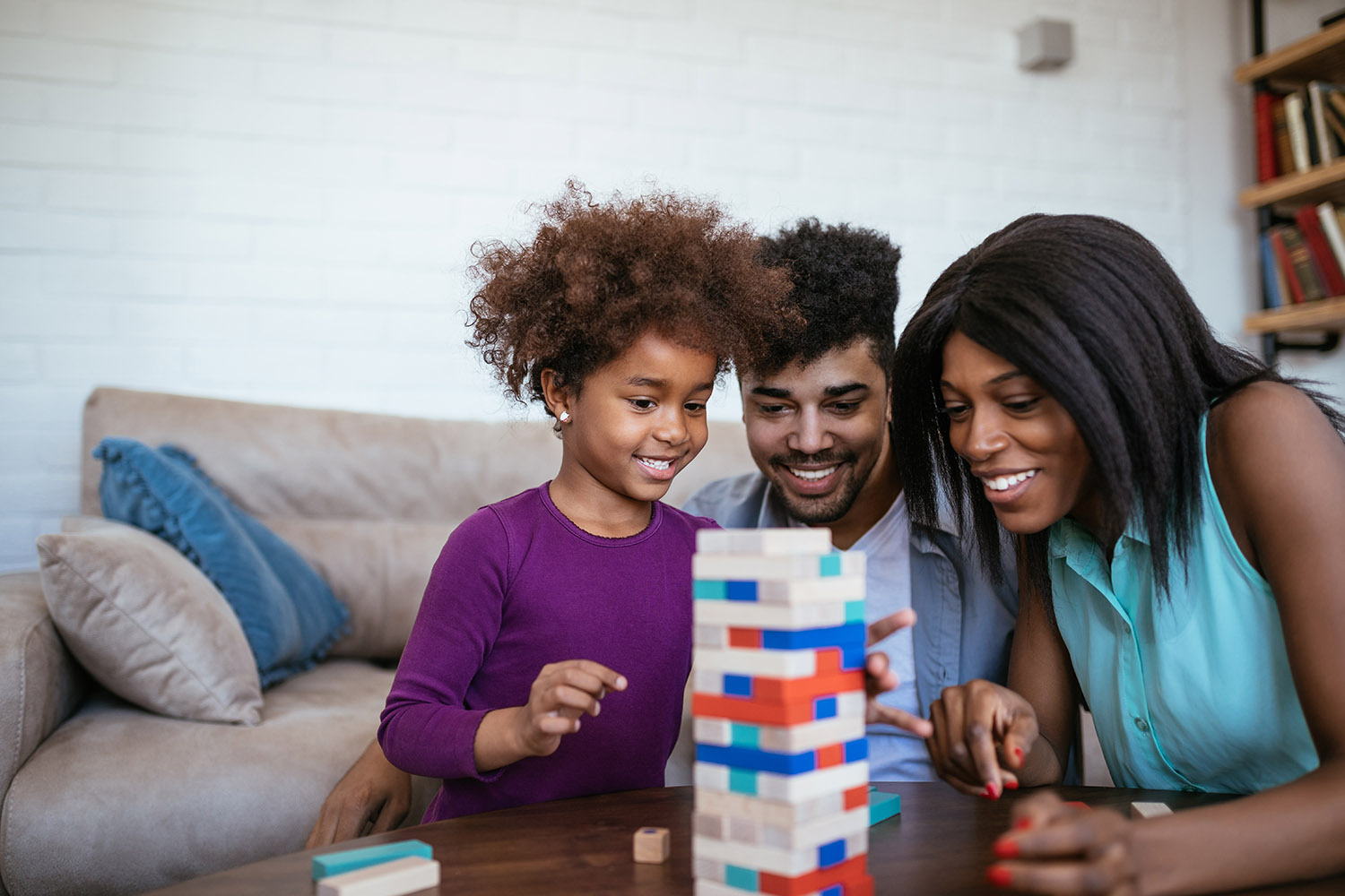 black family with young girl playing jenga kids gift guide